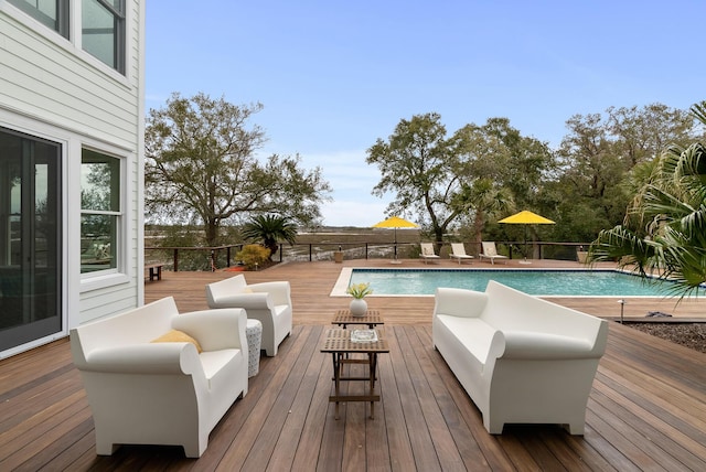 view of pool featuring a fenced in pool, outdoor lounge area, and a wooden deck