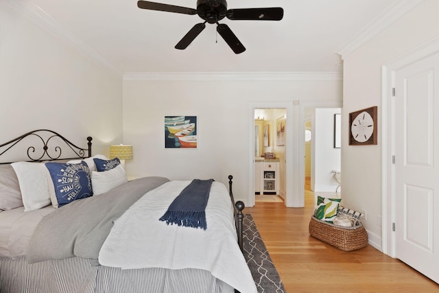 bedroom featuring ensuite bathroom, a ceiling fan, baseboards, ornamental molding, and light wood finished floors