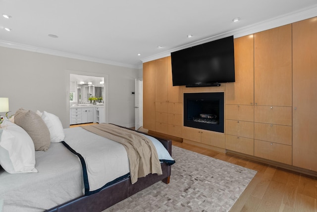 bedroom featuring light wood-style floors, recessed lighting, a fireplace, and crown molding