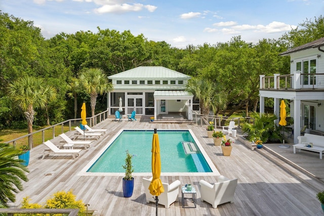 view of pool with an outdoor structure, a deck, a fenced in pool, and an exterior structure