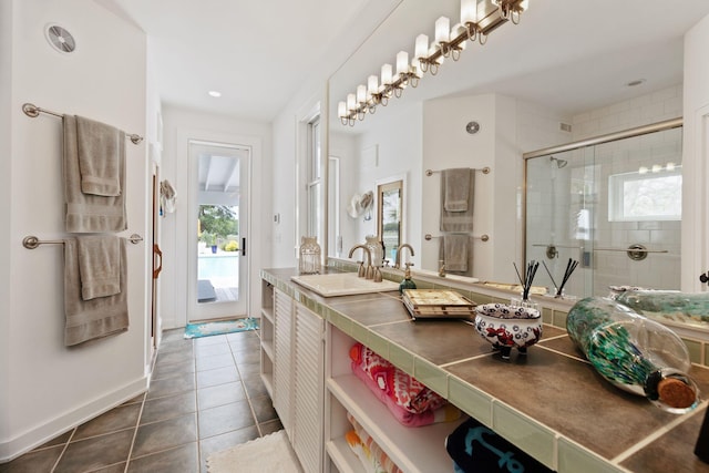 bathroom with a stall shower, tile patterned flooring, vanity, and baseboards