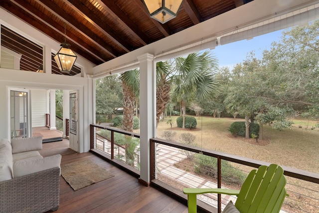 unfurnished sunroom featuring plenty of natural light, wood ceiling, and vaulted ceiling with beams