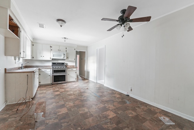 kitchen featuring ceiling fan, sink, double oven range, white cabinets, and ornamental molding