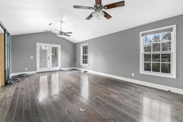 unfurnished living room with french doors, vaulted ceiling, ceiling fan, a barn door, and dark hardwood / wood-style floors