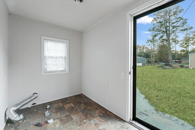 unfurnished room featuring wooden walls