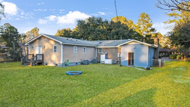 rear view of property with a yard and central air condition unit