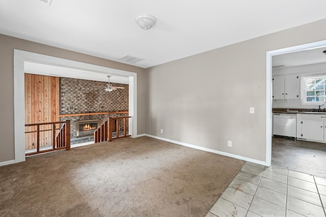 unfurnished living room featuring ceiling fan, light tile patterned floors, wooden walls, and a brick fireplace