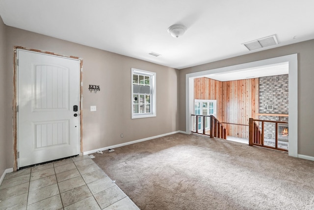 entryway with wood walls and light colored carpet