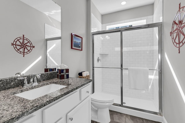 bathroom featuring vanity, an enclosed shower, and toilet