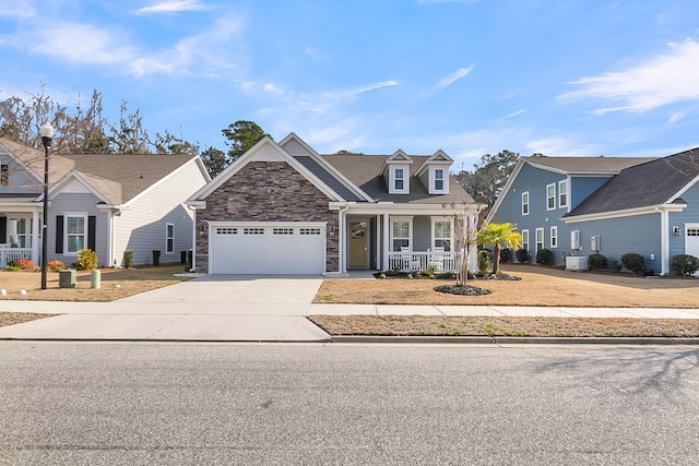 view of front of home with a porch, a garage, and central AC