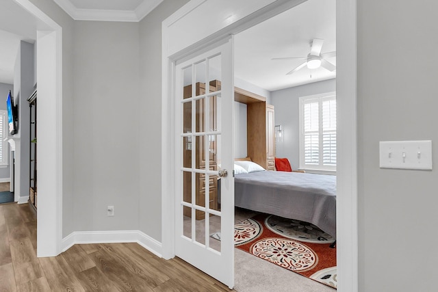 bedroom with ornamental molding, light hardwood / wood-style floors, and french doors