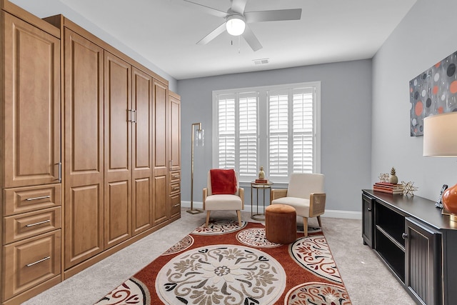 living area with ceiling fan and light colored carpet