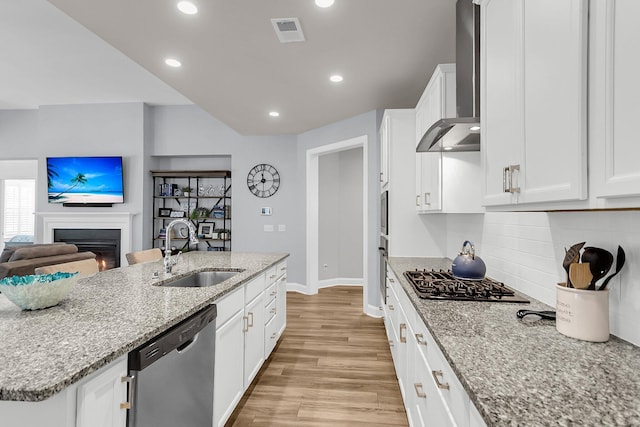 kitchen with white cabinetry, appliances with stainless steel finishes, sink, and wall chimney exhaust hood