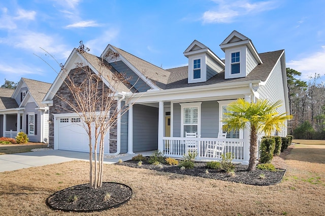 view of front of home with a garage, a front yard, and covered porch