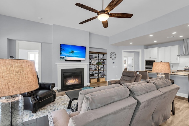 living room with ceiling fan and light wood-type flooring