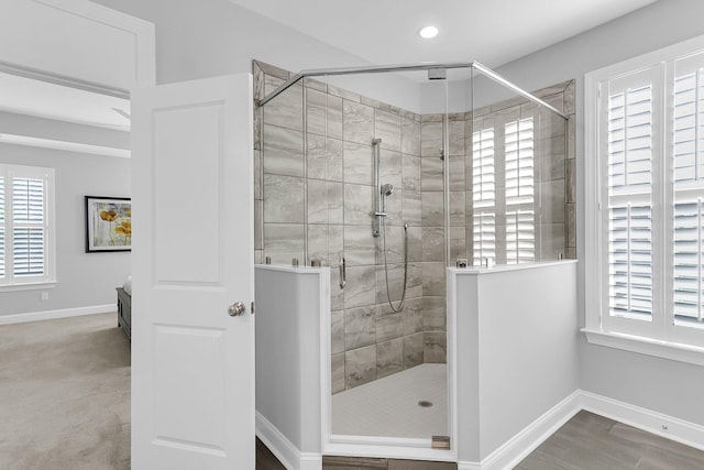 bathroom featuring a wealth of natural light and a shower with shower door