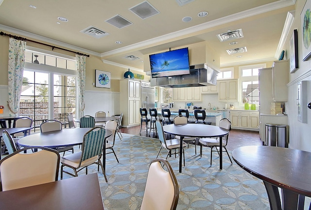 dining room with crown molding, sink, and a wealth of natural light