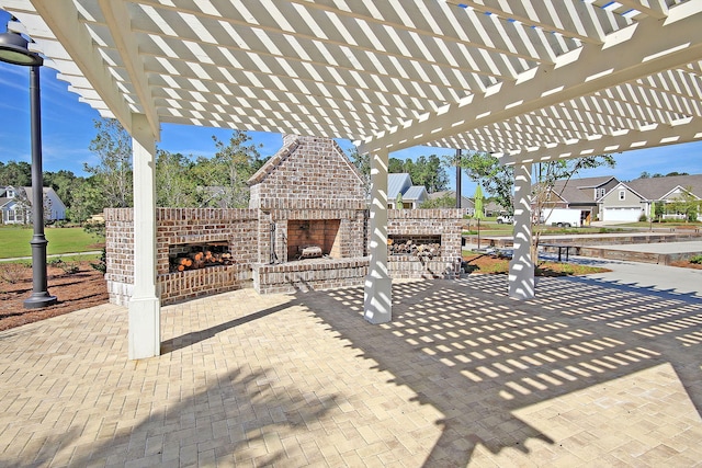 view of patio featuring an outdoor brick fireplace and a pergola