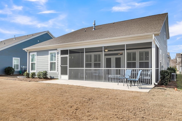 rear view of property with a sunroom, a lawn, central air condition unit, and a patio area