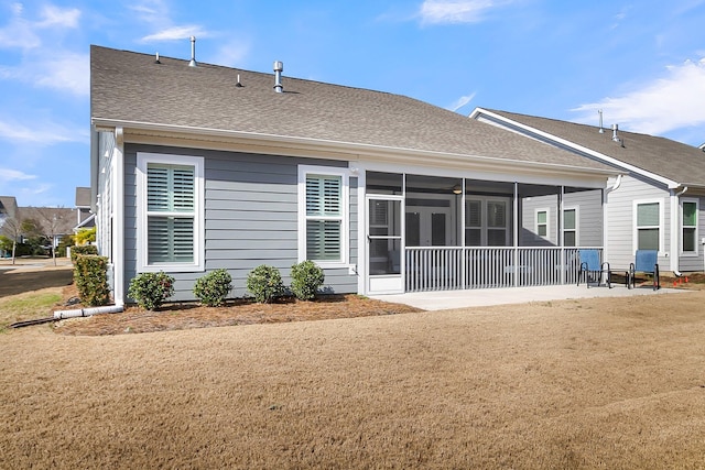 back of house featuring a lawn, a sunroom, and a patio area