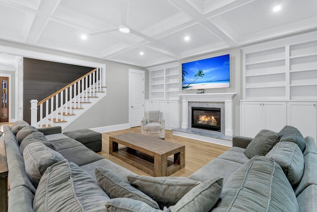 living room with beam ceiling, light hardwood / wood-style flooring, coffered ceiling, and built in features