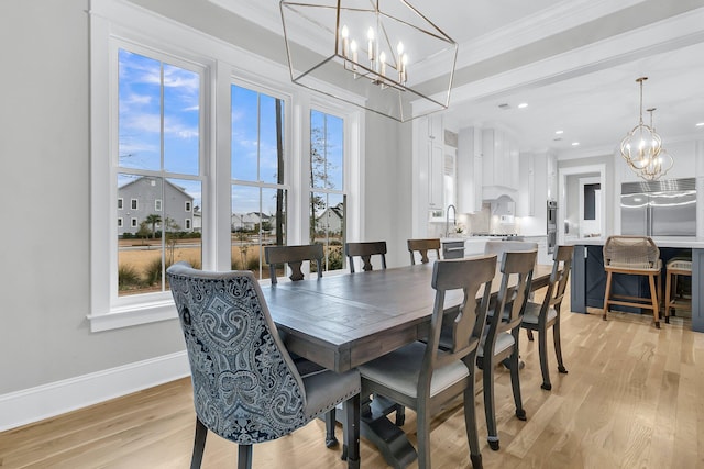 dining area featuring a notable chandelier, ornamental molding, light hardwood / wood-style floors, and plenty of natural light