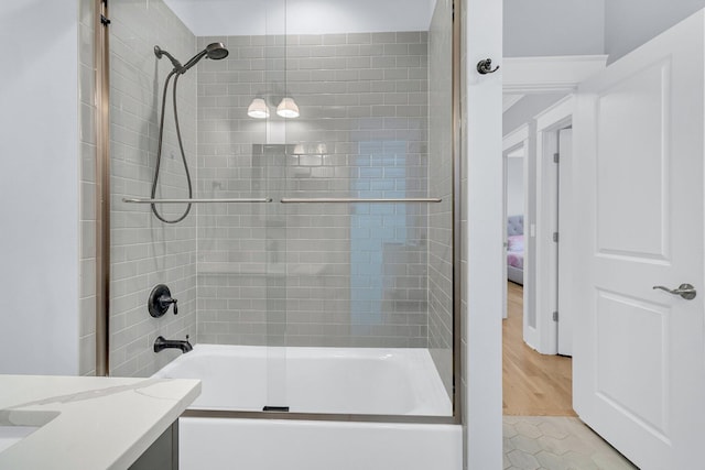 bathroom with enclosed tub / shower combo, tile patterned flooring, and vanity