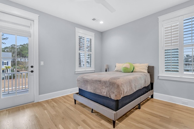 bedroom featuring multiple windows, ceiling fan, access to exterior, and hardwood / wood-style floors