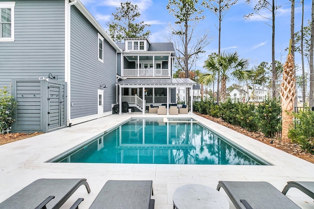 view of pool with a sunroom and a patio area