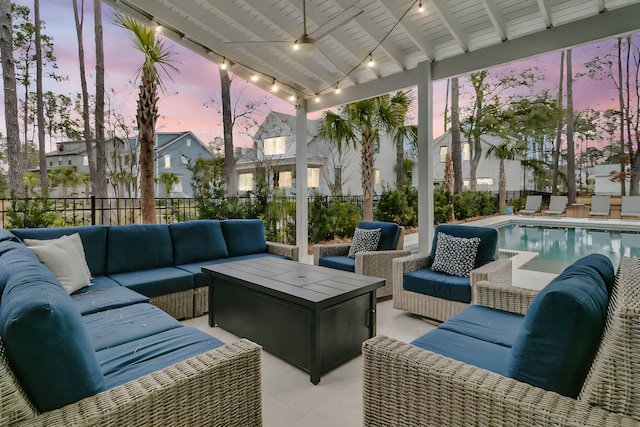 patio terrace at dusk featuring a fenced in pool and outdoor lounge area