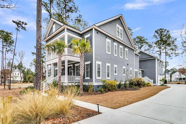 view of side of home with covered porch and a balcony