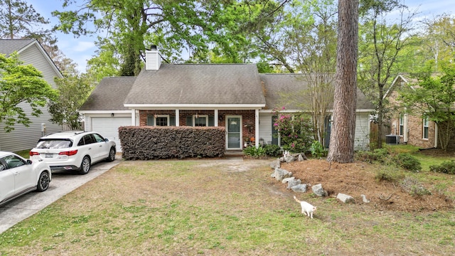 view of front of home with an attached garage, a chimney, cooling unit, brick siding, and roof with shingles