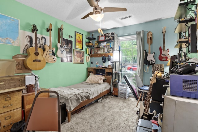 bedroom with visible vents, ceiling fan, carpet flooring, and a textured ceiling