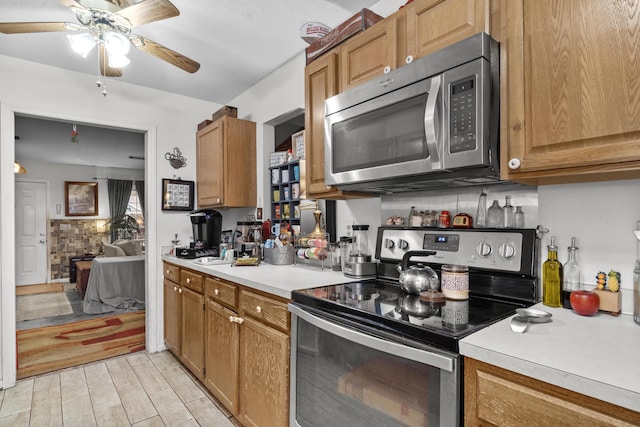 kitchen featuring light wood-style flooring, light countertops, a ceiling fan, and stainless steel appliances
