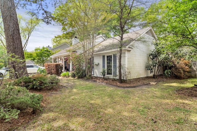 view of front of house featuring a front lawn, fence, and a chimney