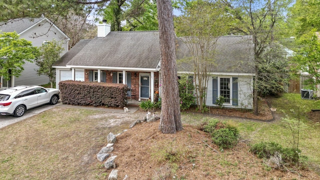 view of front of house with central AC, a shingled roof, an attached garage, a chimney, and brick siding