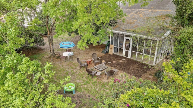 view of yard featuring a sunroom and a fire pit