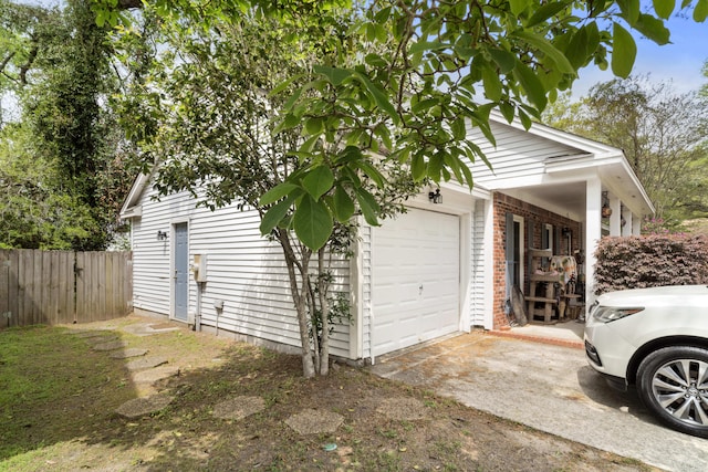 garage with driveway and fence