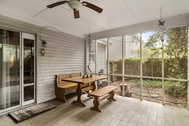sunroom with outdoor dining space and a ceiling fan