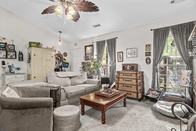 living area with carpet flooring, vaulted ceiling, a ceiling fan, and visible vents