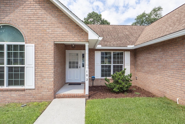 doorway to property featuring a lawn