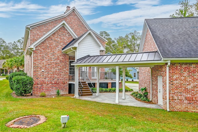 rear view of property with a yard and a carport