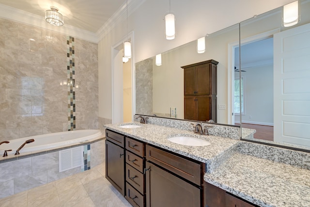 bathroom with vanity, tiled bath, and crown molding