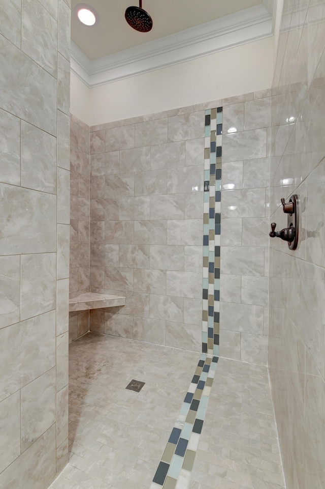 bathroom featuring tiled shower and crown molding