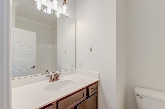 bathroom with toilet, vanity, and crown molding