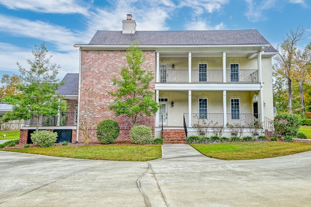 view of front of home with a porch, a front yard, and a balcony