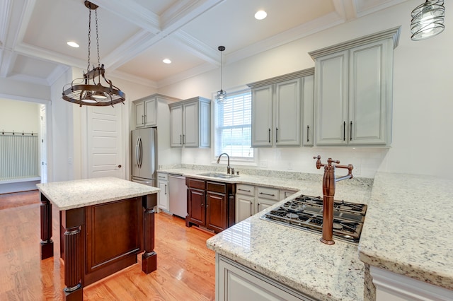 kitchen with light hardwood / wood-style floors, sink, a breakfast bar area, stainless steel dishwasher, and coffered ceiling