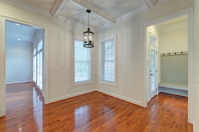 empty room featuring a wealth of natural light, wood-type flooring, and beam ceiling