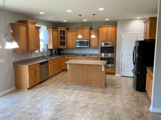 kitchen with black appliances, a kitchen island, sink, and hanging light fixtures