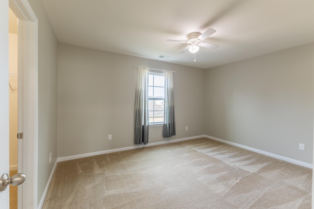 carpeted spare room featuring ceiling fan